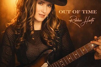 Robbie Harte in cowboy hat holding guitar for country music promotion.